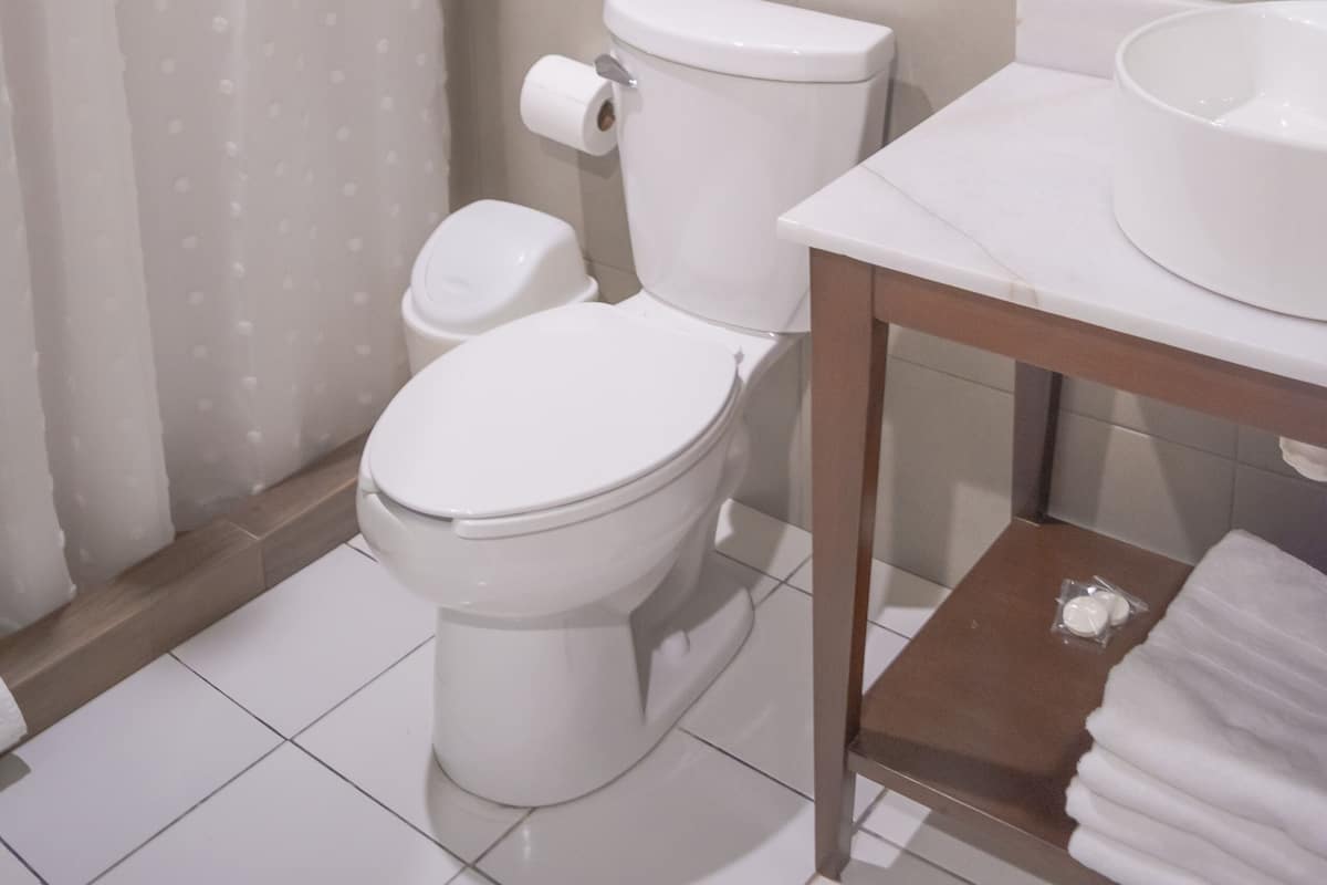 Un baño con inodoro, lavamanos y cortina de ducha.