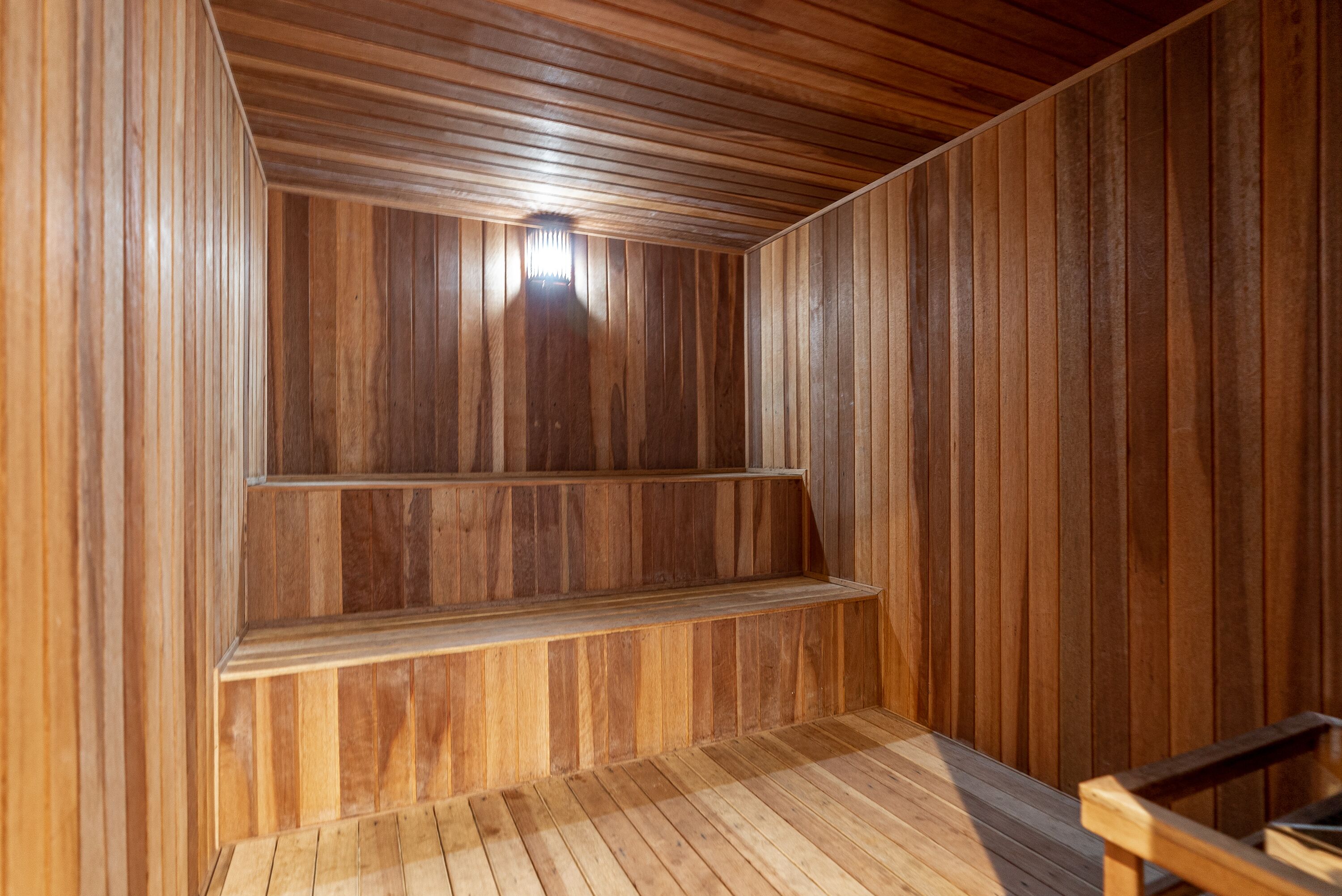 Un interior de madera con un banco y techo inclinado.