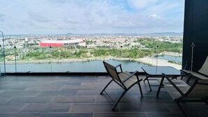 A spacious balcony with a view of a cityscape and a body of water. - Central 102 Apartments (Mazatlán)