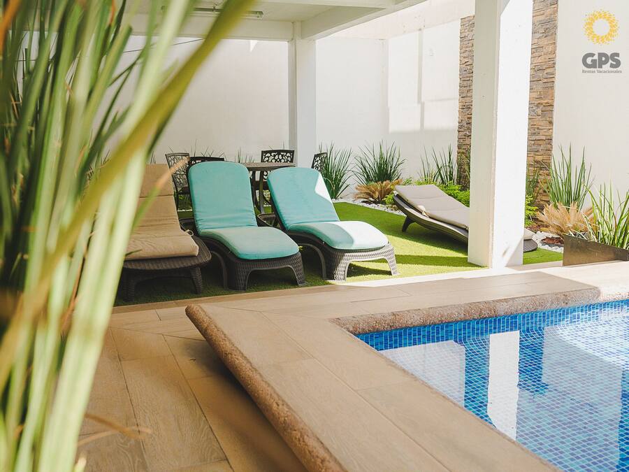 A poolside area with lounge chairs and a small garden.