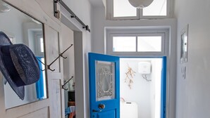 Ein Flur mit einer blauen Tür, einem Schiffmodell und einem Fliesenboden.