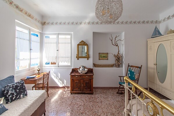 Una stanza arredata con un letto, una scrivania, una cassettiera, una sedia e uno specchio decorativo.