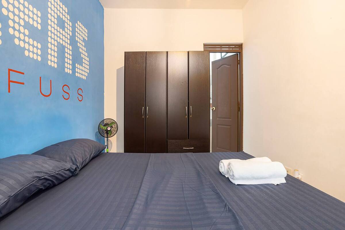 Quarto com cama, parede com padrão de pontos e guarda-roupa.