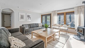 Ein modernes Wohnzimmer mit einer Couch, einem Couchtisch und einem Kamin.