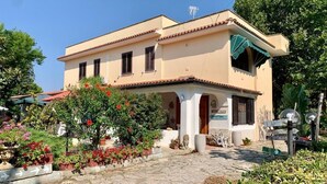 A two-story building with a beige facade and a tiled roof, featuring a covered entrance with columns and a sign that reads "Welcome." - Villa Anna (Brindisi)