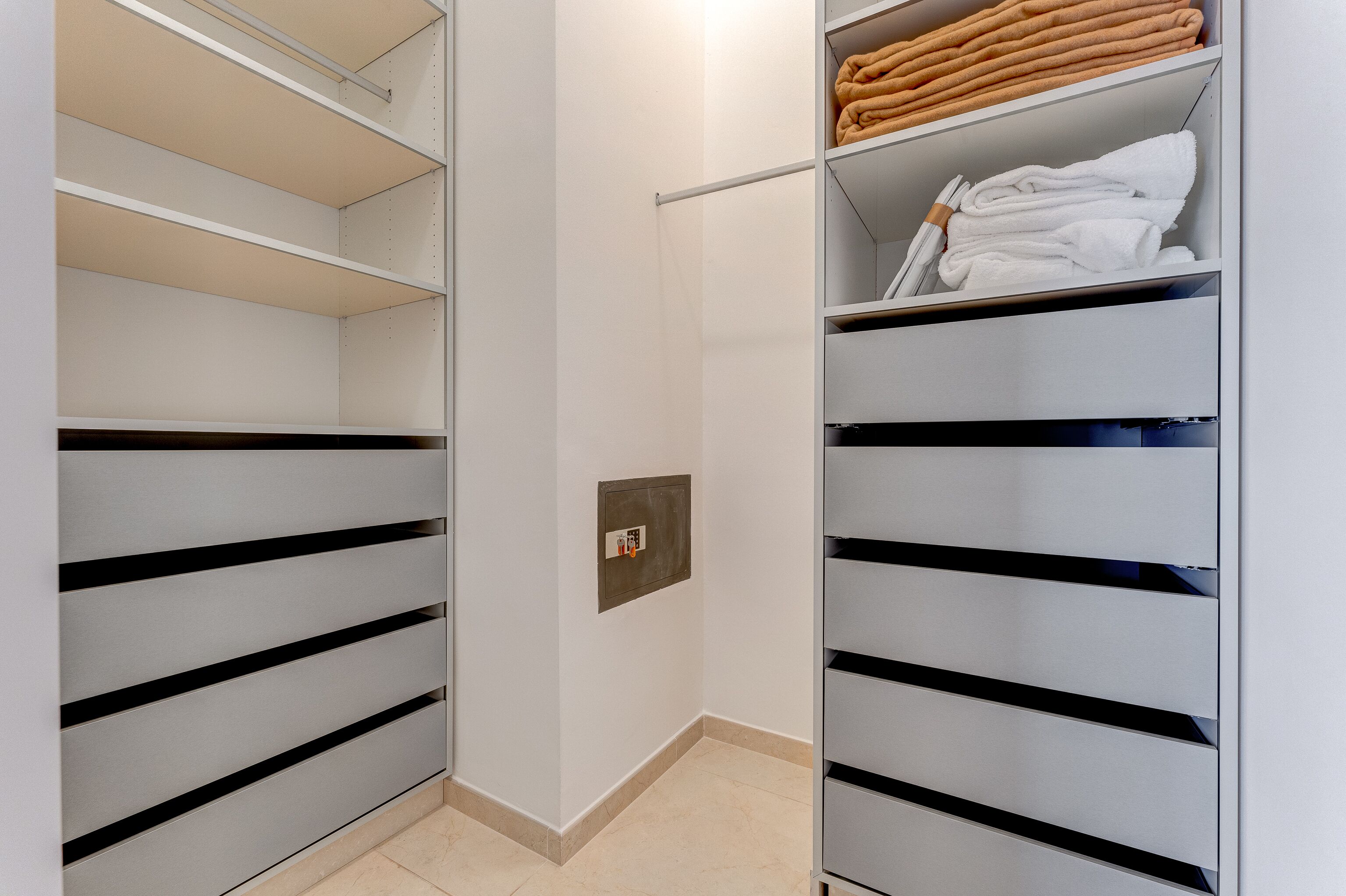 A walk-in closet with open shelves and a built-in heater.