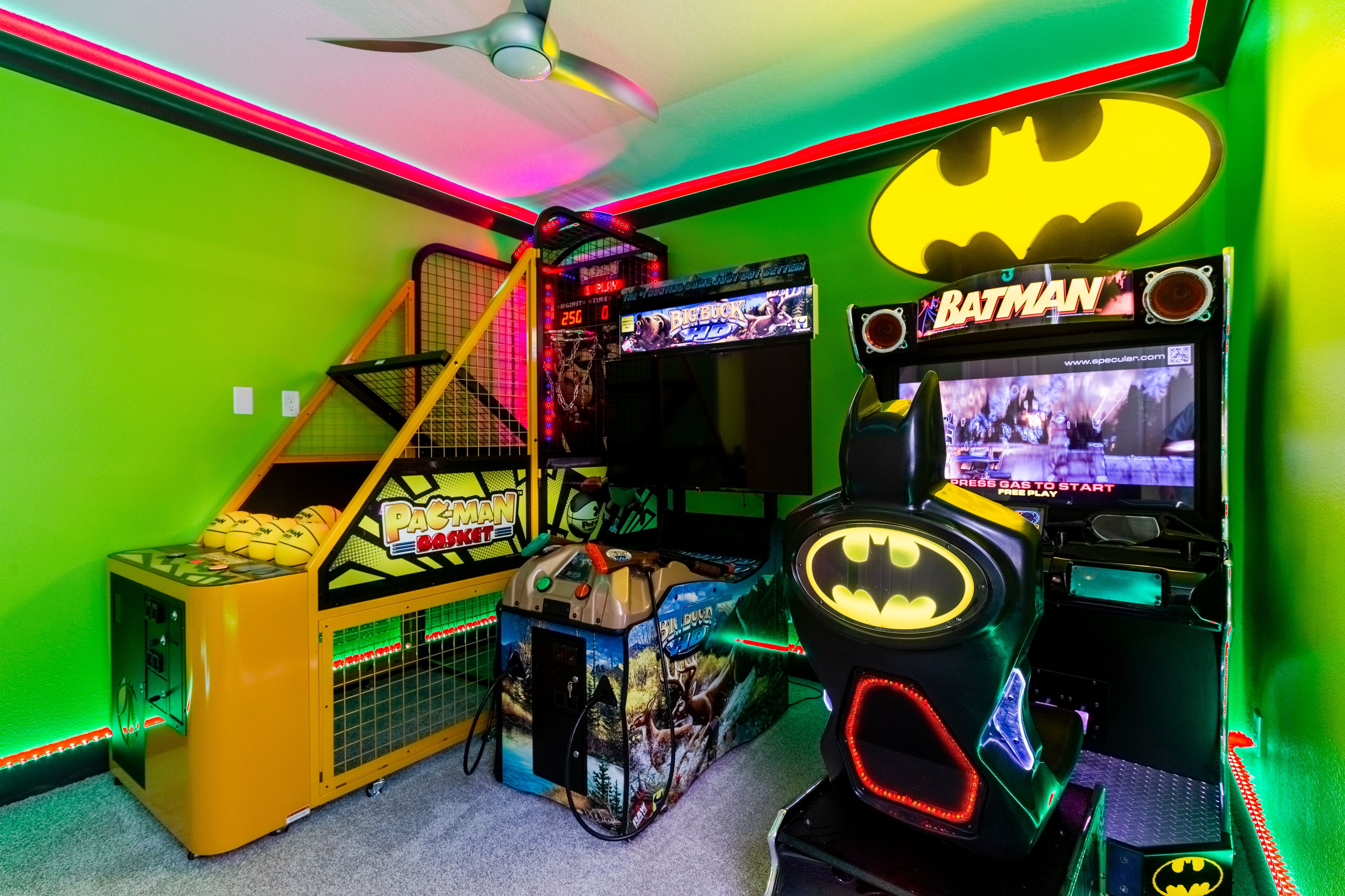 Un salón de juegos recreativos con diversas máquinas, incluyendo una con tema de Batman y una máquina de Pac-Man.