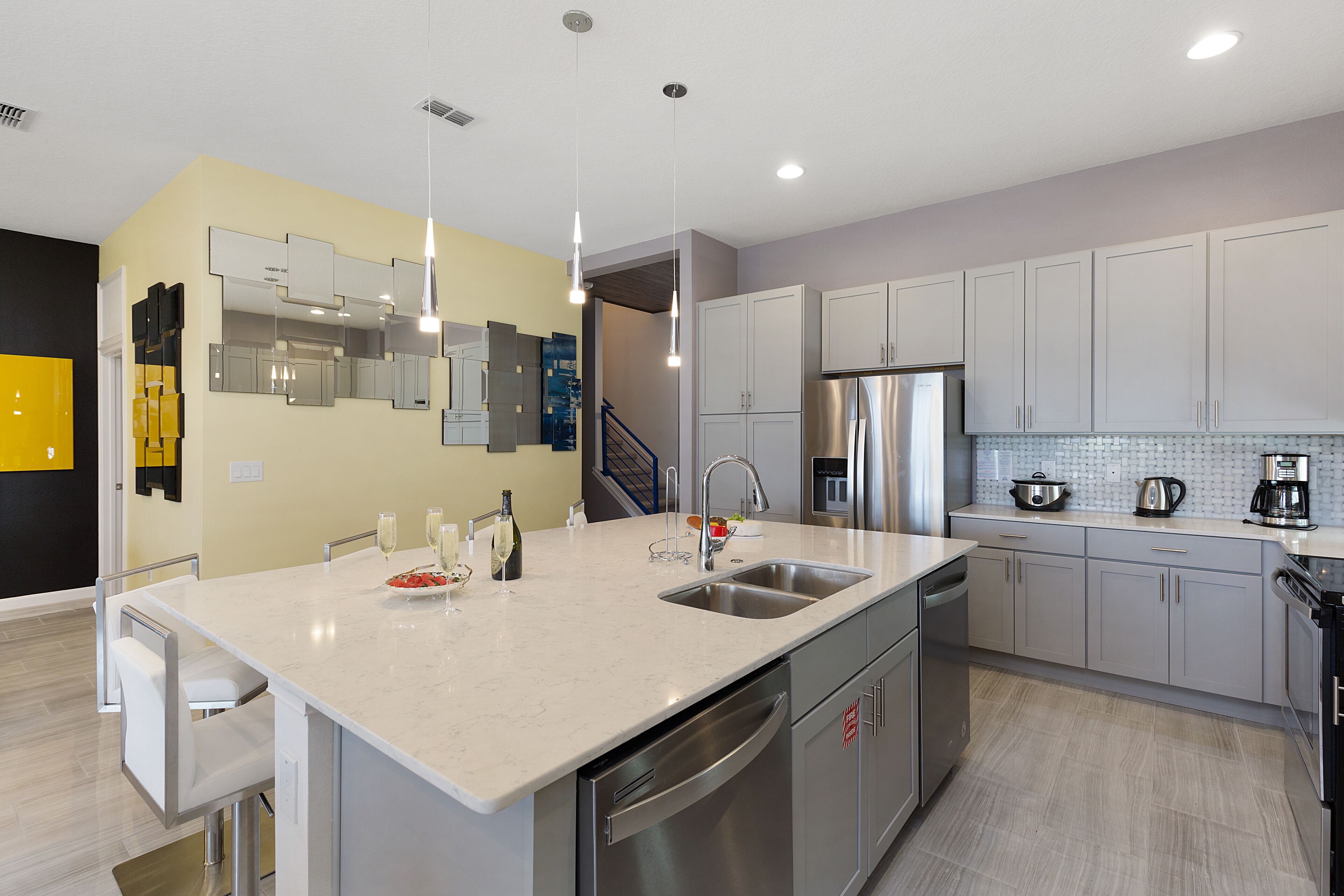 A modern kitchen with a large island, stainless steel appliances, and a neutral color palette.