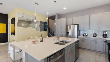 A modern kitchen with a large island, stainless steel appliances, and a neutral color palette.