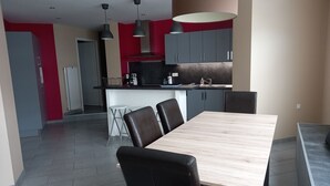 Una cocina moderna con armarios grises, una isla central e iluminación colgante.