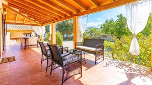 An outdoor patio with wooden beams, a table, chairs, and a bench. - GALLINA Finca with pool for 8 people in Alcudia (Alcúdia)