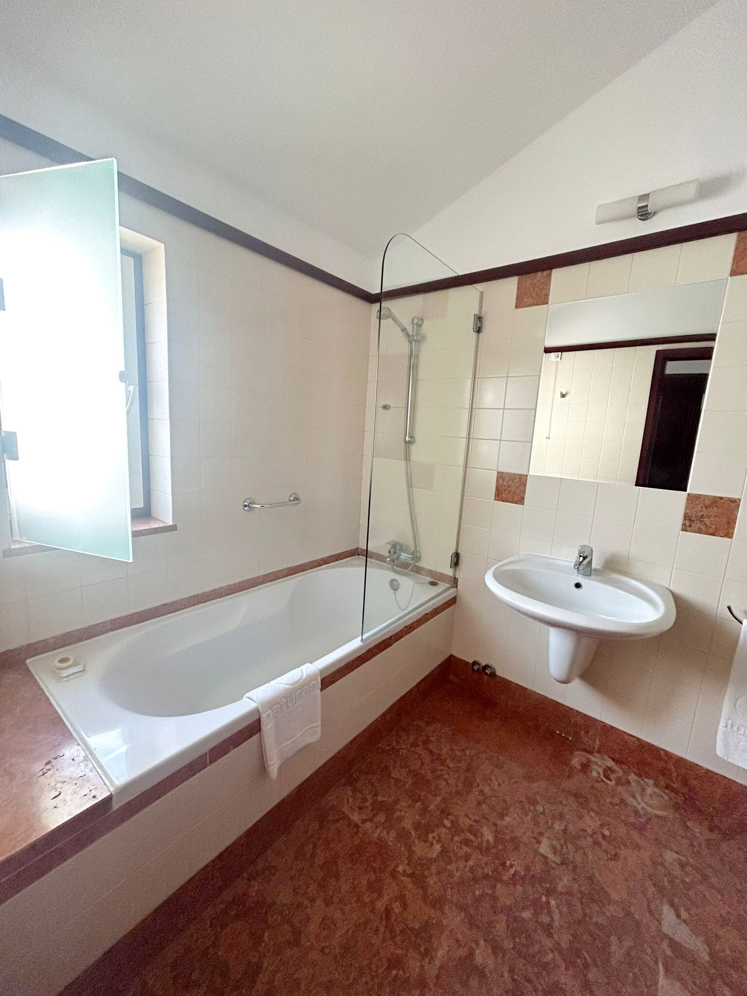 A bathroom with a bathtub, a shower, and a sink.