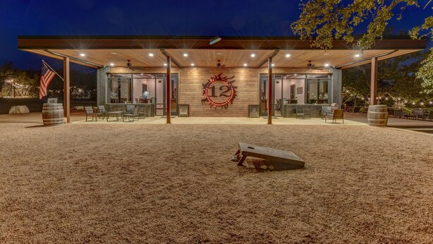 Een modern gebouw met een overdekt terras, een groot bord met het cijfer 12, en een Amerikaanse vlag.