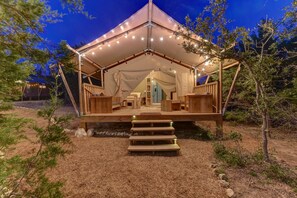 A tented accommodation with a wooden deck, steps leading to the entrance, and string lights. - Glamping Getaway on Winery in Hill Country (Johnson City)