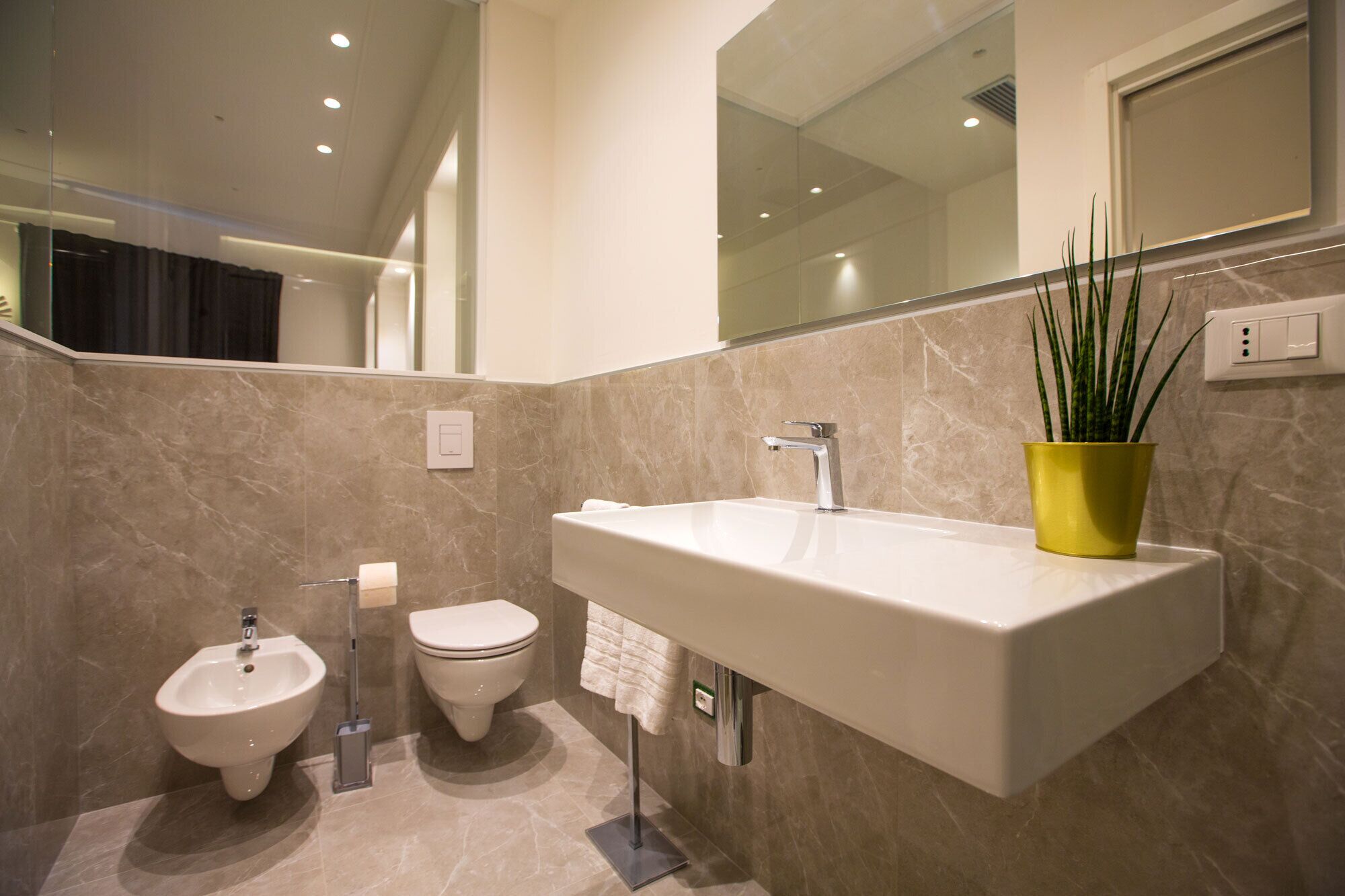 Une salle de bain moderne avec un grand lavabo, un bidet et des toilettes.