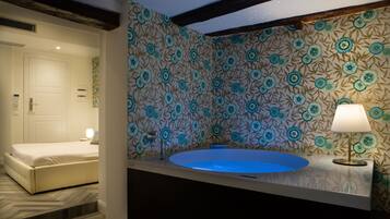 Une salle de bain avec une grande baignoire, un miroir et un mur décoré de motifs.