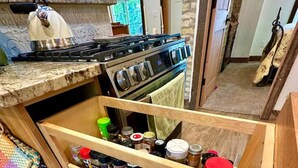 Una cocina con especiero empotrado y estufa.