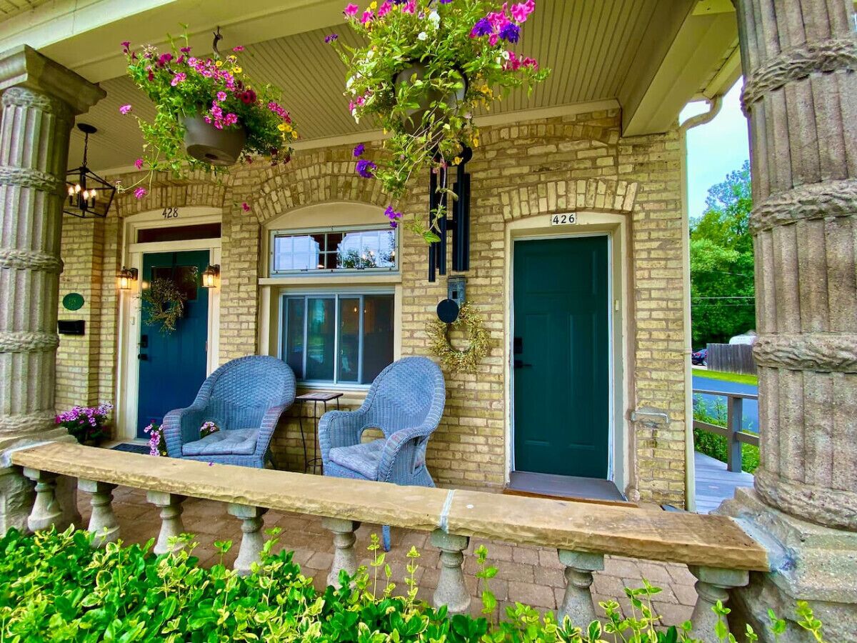 A stone building with two doors, numbered 426 and 427, and a bench outside.