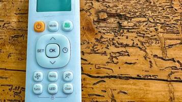 A white MRCOOL remote control on a wooden surface.