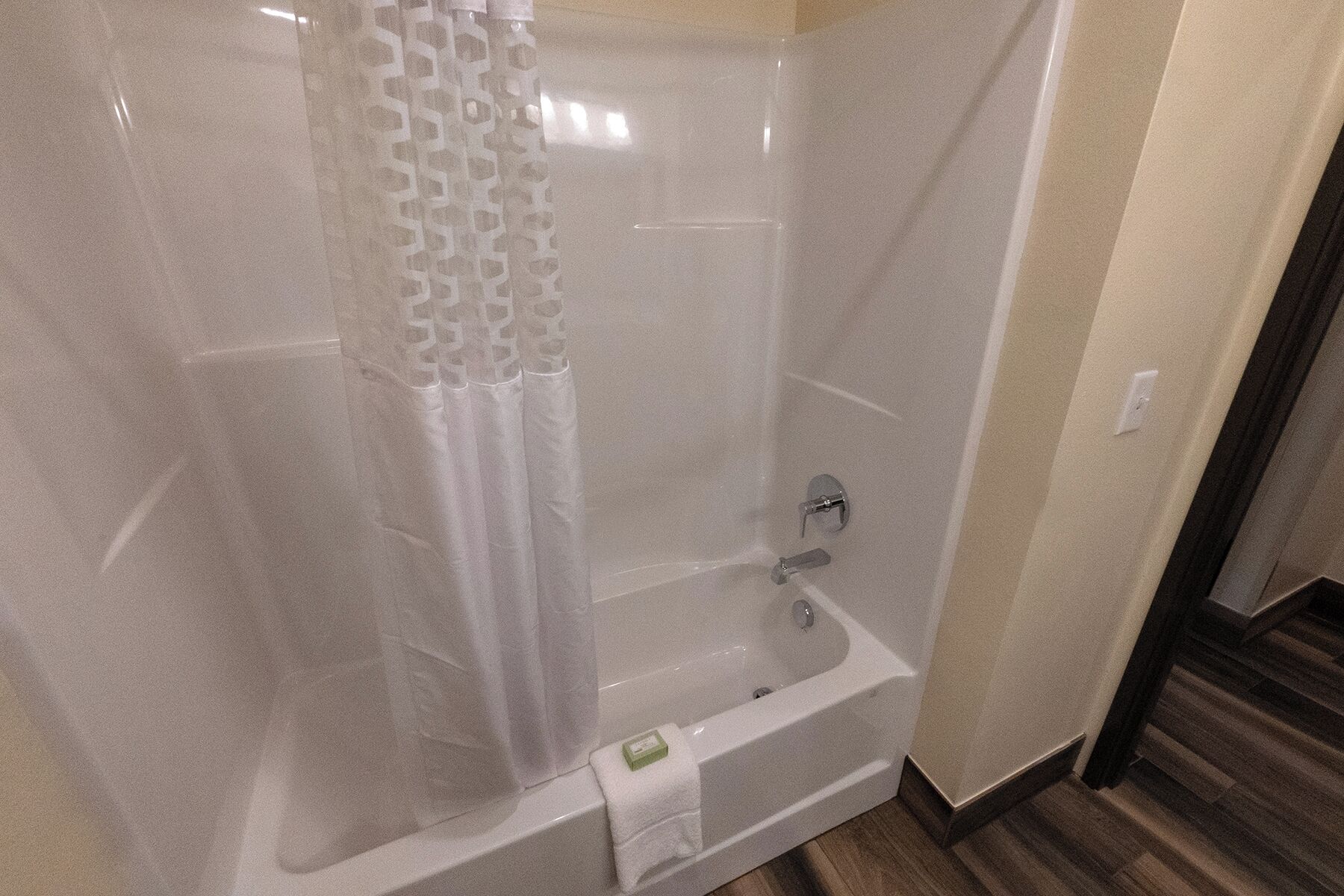 Un baño con bañera, cortina de ducha y barra para toallas.