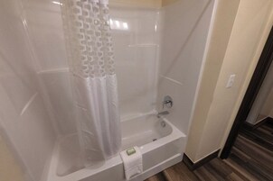 Un baño con bañera, cortina de ducha y barra para toallas.