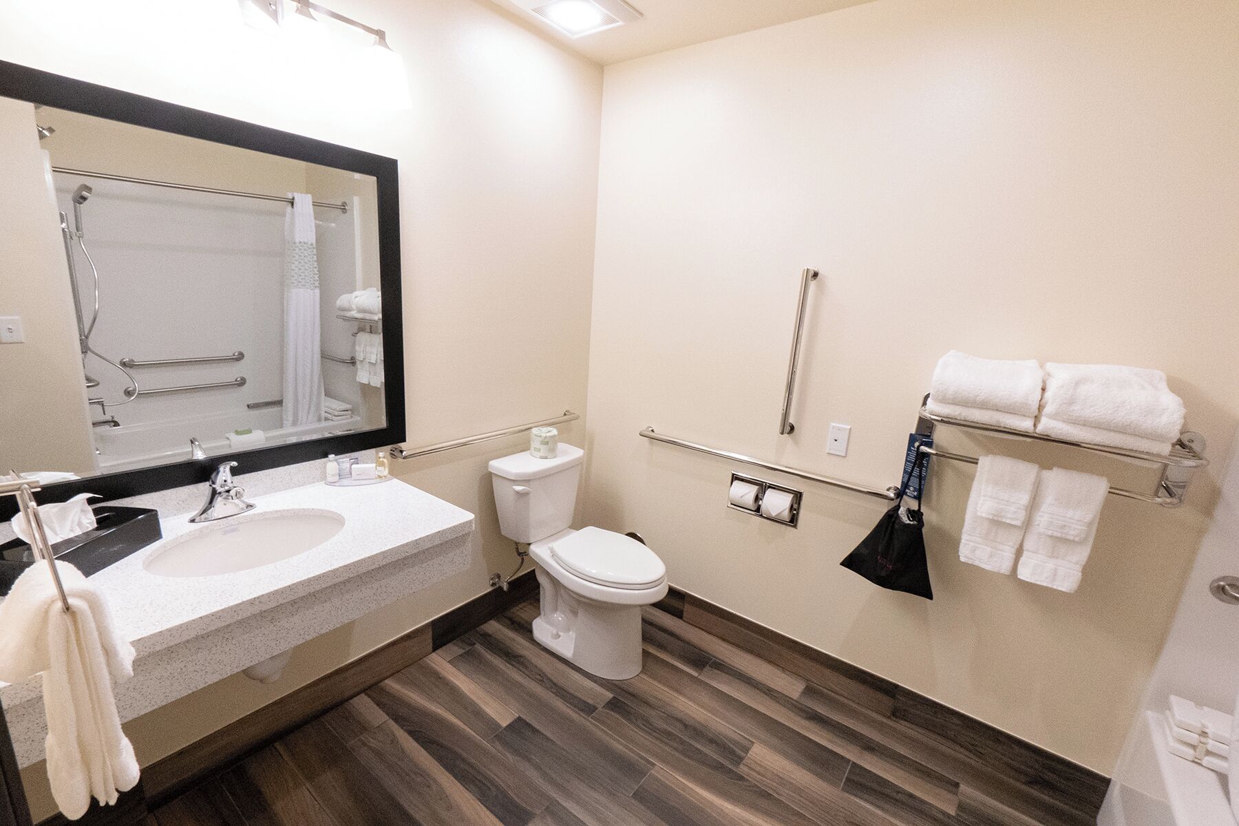 A modern bathroom with a sink, toilet, and mirror.