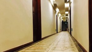 A long, narrow hallway with a patterned floor and wooden doors on either side. - Nanyi Hotel (Chishui)