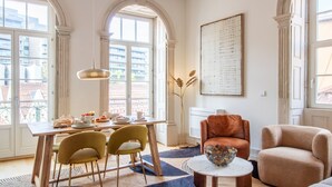 A dining area with a table set for two, a modern chair, and a decorative bowl on a side table. - Casa Azul - Santa Marinha (Vila Nova de Gaia)