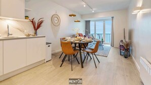 A modern kitchen with a dining area, a large window, and a balcony. - Seagusta - sea view apartment in Middelkerke (Middelkerke)