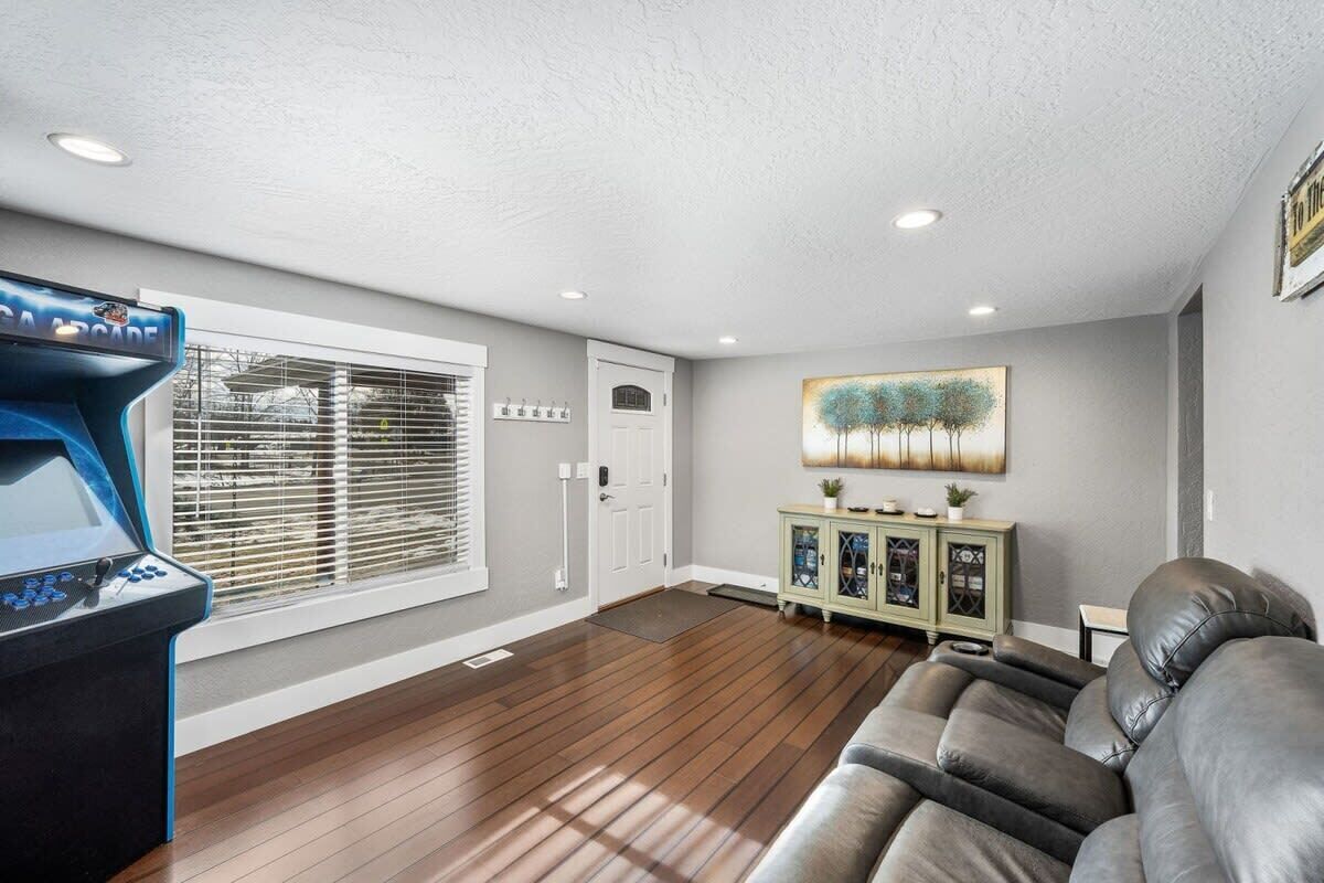 A living room with a large couch, a game console, a cabinet, and a door.
