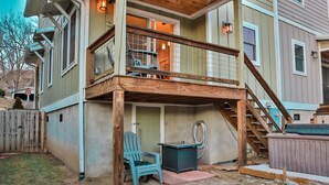 A two-story house with a wooden deck, a hot tub, and a covered outdoor seating area. - Walk to Train! Pet-Friendly Townhome! (Bryson City)