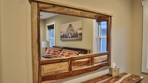 A bedroom with a wooden headboard, a bedside table, and a mirror. - Walk to Train! Pet-Friendly Townhome! (Bryson City)