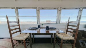 Une table à manger avec quatre chaises, un ordinateur portable et une petite plante.