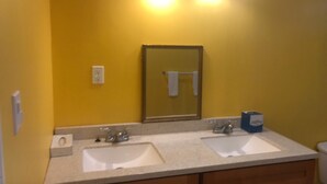 A bathroom with two sinks, a mirror, and a towel rack. - PALMVILLO MASTER SUIT (dominica)