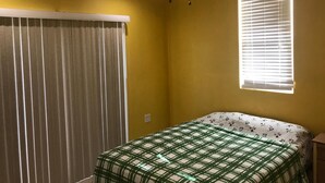 A bedroom with a bed, a ceiling fan, a window with blinds, and a curtain. - PALMVILLO MASTER SUIT (dominica)