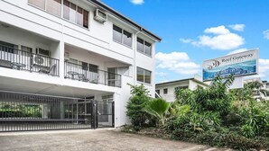 A multi-story building with a sign advertising 'Reef Gateway Apartments'.