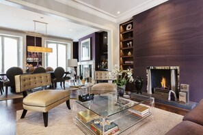 A modern living room with a glass coffee table, leather sofa, and a fireplace. - Flawless Hideout in central London (London)