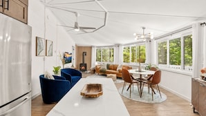 Una cocina amplia con comedor, chimenea empotrada y ventanas grandes con vistas al exterior.