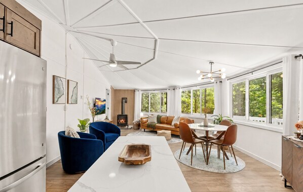 Una cocina amplia con comedor, chimenea empotrada y ventanas grandes con vistas al exterior.