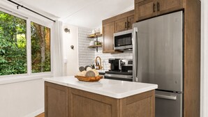 Una cocina moderna con una isla grande, electrodomésticos de acero inoxidable y armarios de madera.