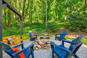 Un espacio al aire libre con sillas Adirondack, un brasero y un conjunto de columpios.