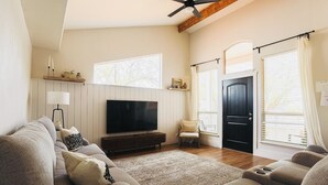 A living room with a TV, sofas, a chair, a lamp, and a ceiling fan. - Charming home walking distance from downtown Kanab, w/King Suite (Kanab)