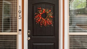 A black front door with a wreath, a number '195' on the wall, and a ceiling fan above. - Charming home walking distance from downtown Kanab, w/King Suite (Kanab)