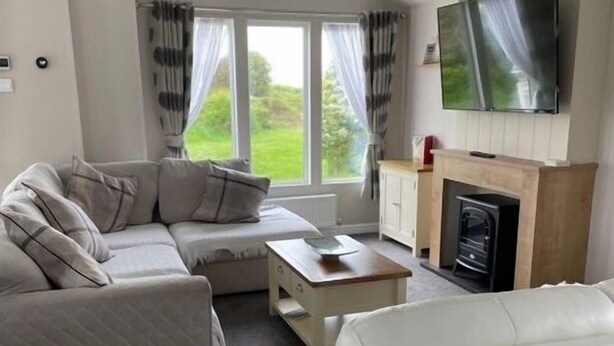 Een moderne woonkamer met een bank, een salontafel en een open haard.