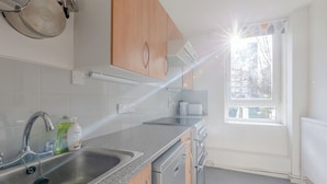 Une cuisine moderne dotée d’appareils électroménagers en acier inoxydable, d’un plan de travail en granit et d’une fenêtre laissant entrer la lumière naturelle.