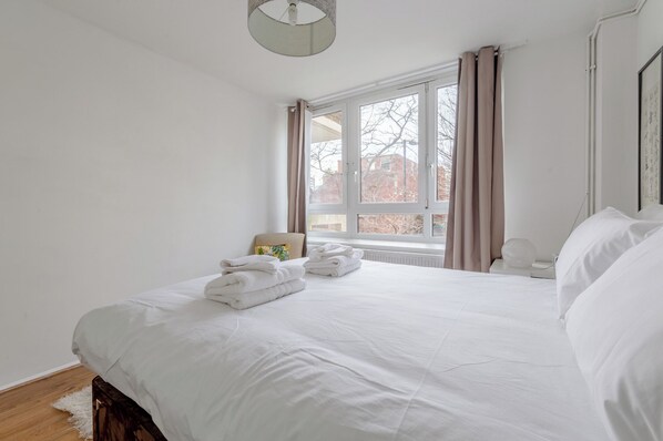 Une chambre d’hôtel avec un grand lit, une fenêtre avec des rideaux et une vue sur l’extérieur.