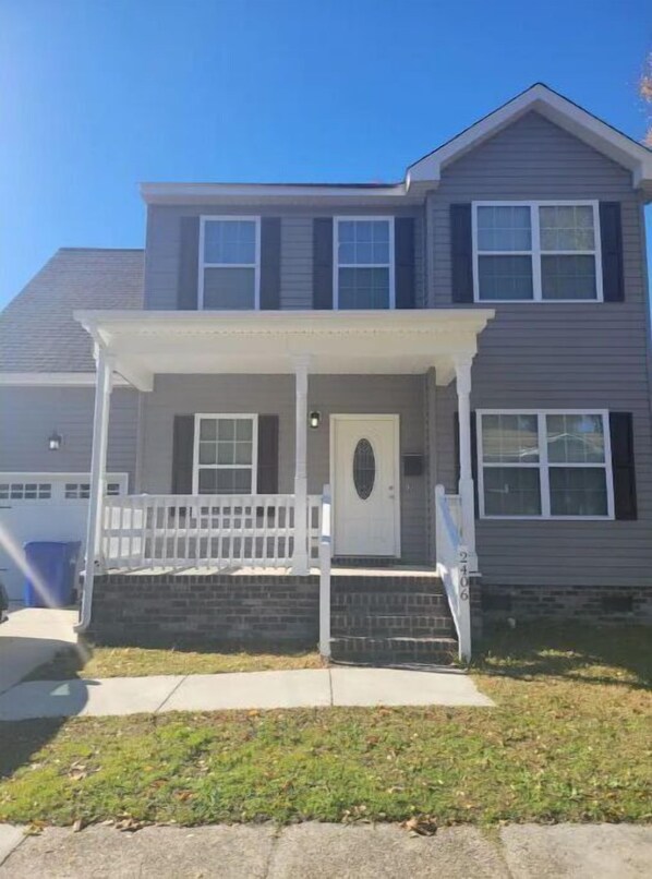 Stunning two-story home with a central entrance and a charming porch area.