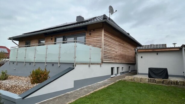 A modern house with a sloped roof, a balcony with glass railings, and a satellite dish. - Modern vacation apartment Knüllwald (Knüllwald)