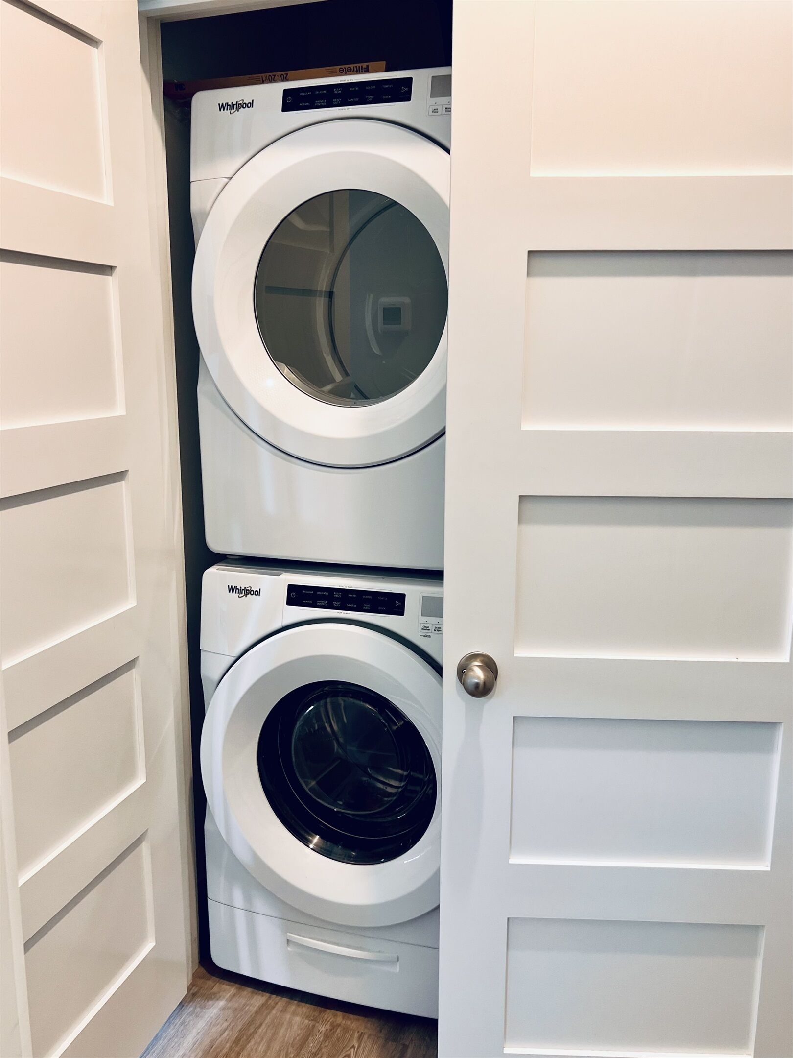 Ein kleiner Hauswirtschaftsraum mit zwei Türen und Waschmaschinen der Marke Whirlpool.