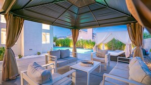 An outdoor patio with a pool, cushioned seating, and a pergola structure. - The Great Escape: Pool Home Oasis in the Desert (Indio)